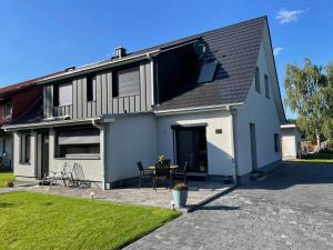 a white house with a black roof and a patio at Ferienwohnung Hardo in Alt Schwerin