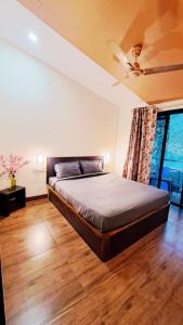 a bedroom with a bed and a ceiling fan at Neuaura Stays in Mahabaleshwar