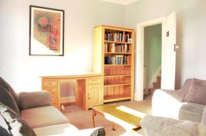 a living room with a couch and a book shelf at Suite 2 - Chic Private Room near City Centre in Manchester