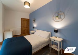 um quarto azul com uma cama e duas mesas em Luke Stays - Grosvenor Road em Jesmond