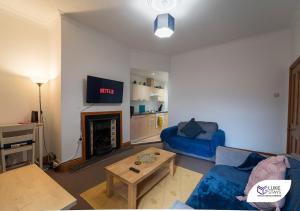 a living room with a blue couch and a fireplace at Luke Stays - Grosvenor Road in Jesmond