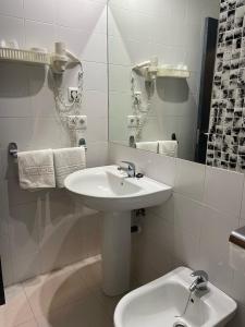a white bathroom with a sink and a mirror at La Albarizuela in Jerez de la Frontera