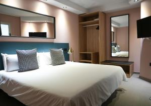 a bedroom with a large white bed with a large mirror at Poem Suites by Airnest in Las Palmas de Gran Canaria