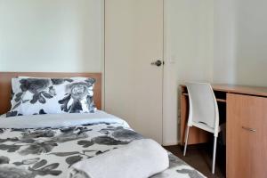 a bedroom with a bed and a desk and a chair at City Centre Apt - 3 Bed/Parking/CBD/WiFi in Adelaide