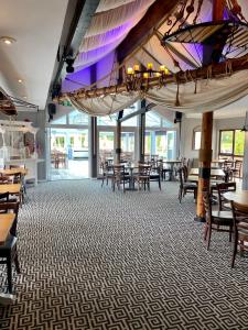 a dining room with tables and chairs and windows at The Riverside inn in Saltford