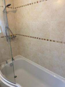 a bathroom with a tub and a shower stall at Tupenny Cottage, Old Mill Farm, Cotswold Water Park in Cirencester +10 photos