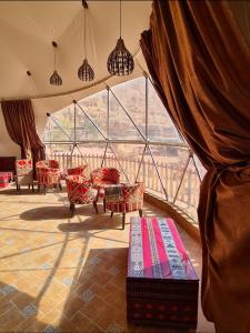 a room with chairs and a large window at Hasan Zawaideh Camp in Wadi Rum