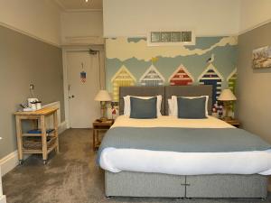 a bedroom with a large bed and a mural of houses at Beachside Guest House in Llandudno