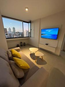 a living room with a couch and a flat screen tv at Hermoso departamento de un dormitorio en Neuquén in Neuquén