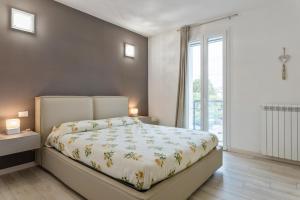 um quarto com uma cama e uma grande janela em Terrazza Arrighi - Affitti Brevi Italia em Lucca