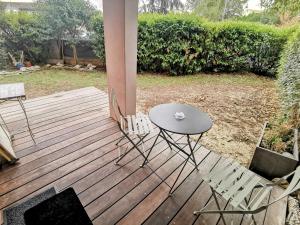 une table et deux chaises sur une terrasse en bois dans l'établissement La Bulle Bleue - Parking-Terrasse-aéoport-MEET, à Blagnac