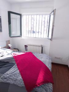 sypialnia z łóżkiem przykrytym czerwonym kocem w obiekcie Hostal El Caracol w mieście Valdemoro