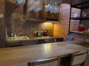 a kitchen with a wooden table and a sink at Kauba Apartment in Viljandi