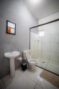 a bathroom with a toilet and a sink and a shower at Hotel GranDourados in Dourados