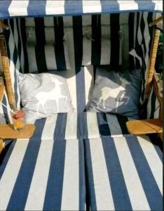 - un lit avec des rayures bleues et blanches et des oreillers dans l'établissement HarzHirsch Bad Sachsa Ferienwohnung, à Bad Sachsa