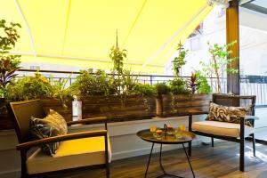 een patio met een tafel, stoelen en planten bij SHELTER in Elegant 2BR with Veranda close to Beach by FeelHome in Tel Aviv