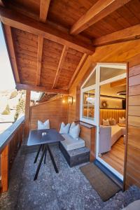 a small house with a balcony with a table and a bed at Penthouse Appartement Fire & Stone in Saalbach-Hinterglemm