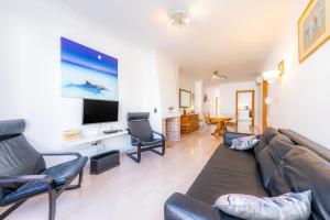 ein Wohnzimmer mit Sofa, Sesseln und Fernseher in der Unterkunft Can Miquel in Can Picafort