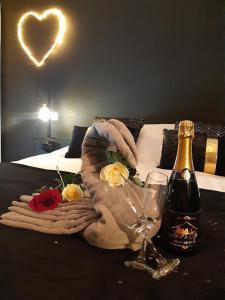 einen Tisch mit einer Flasche Champagner und Blumen darauf in der Unterkunft LOVER'S ROOM OR in Verton