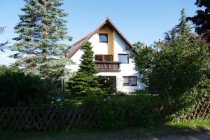 a white house with a balcony and trees at Hus Bruderreck in Klein Vielen