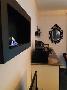 a room with a tv on a wall with a stove at LOVER'S ROOM OR in Verton