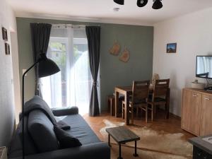 uma sala de estar com um sofá e uma sala de jantar em Appartement Brettljause Ferienhaus Fuenf Sinne em Döbriach