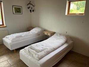 two beds in a room with two tables at Helgafell retreat center in Akureyri
