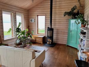 salon z kanapą i piecem opalanym drewnem w obiekcie Helgafell retreat center w Akureyri