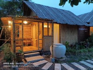 a wooden house with a porch and a table at สวนเกษตรรักษ์ไผ่ Bamboo Conservation Farm in Surin
