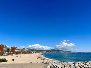 einen Strand mit Menschen auf Sand und Wasser in der Unterkunft salidas en barco in Premiá de Mar