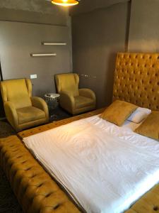 una camera con un grande letto e due sedie di FATIH - TUYAP APART'S a Kırac