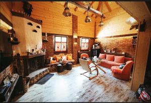 a living room with a couch and a fireplace at Villa FORESTA in Banja Luka