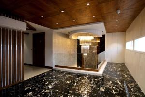 KarnalROYAL LALIT Grand Hotel的大堂设有黑色大理石地板和吊灯。