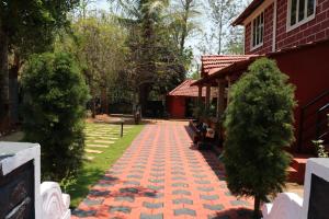 a brick walkway in front of a house at D signature Homestay By Lexstays in Kushālnagar