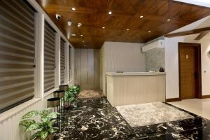 a lobby with a counter and some plants in a building at ROYAL LALIT Grand Hotel in Karnal