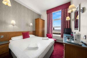 a hotel room with a large bed and a window at Claremont Hotel in Blackpool