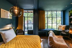 um quarto com uma cama grande e uma janela grande em Luxurious Residence in Vondelpark/Museum District em Amsterdã