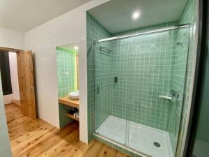 a bathroom with a glass shower with green tiles at Nature & Sea - Casa Vinhateira West Duplex in Caloura