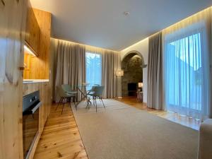 een woonkamer met een tafel, stoelen en ramen bij Nature & Sea - Casa Vinhateira West Duplex in Caloura