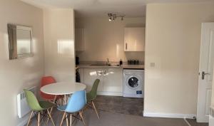 a kitchen with a table and chairs and a laundry room at Broad Gauge Apartments in Wolverhampton