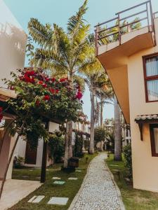 a walkway in front of a building with flowers at A - Pipa Beleza Unidades Particulares in Pipa