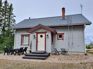 uma casa com uma porta vermelha e uma mesa e cadeiras em Villa Tohonnokka em Kalajoki