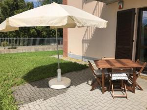 un tavolo e sedie sotto un ombrellone su un patio di Casa alle porte di Pavia a Pavia