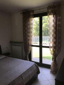 una camera con un letto e una grande finestra di Casa alle porte di Pavia a Pavia