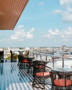 a group of tables and chairs on a balcony at Hotel Agnes in Buriram