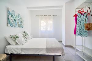 um quarto com uma cama e um vestido pendurado numa prateleira em Villa Rosita Suites en Playa de la Malagueta con terraza em Málaga