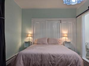 a bedroom with a bed with two lamps on it at Pink Flamingo in Wolfville