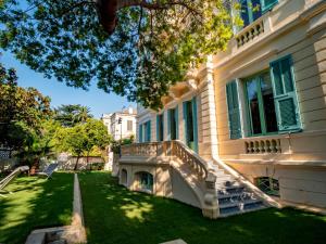 ein Haus mit einer Veranda und einer Liegewiese in der Unterkunft BANANA'S CAMP in Cannes