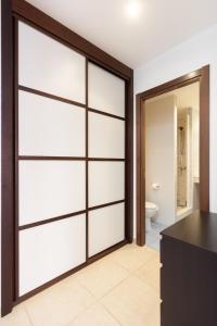 a bathroom with white sliding doors and a toilet at Palm Mar Studio Apartment in Palm-Mar