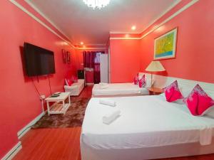 um quarto de hotel com duas camas e uma televisão em Ladolcevita Inland Resort em Cabadbaran